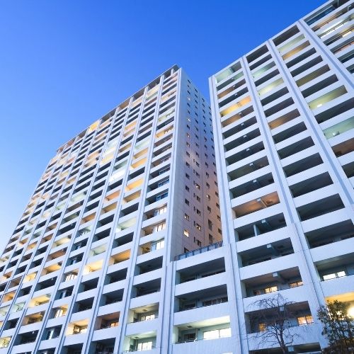 multifamily multi-level white building with balconies.